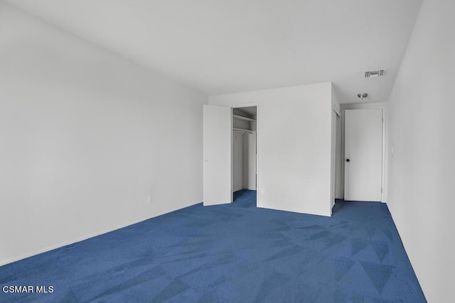 unfurnished bedroom with a closet and dark colored carpet