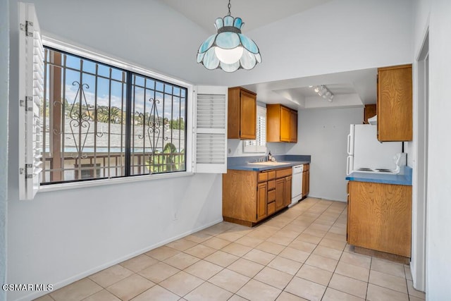 kitchen with light tile patterned flooring, sink, a tray ceiling, and white appliances