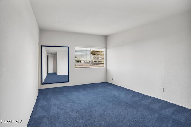 unfurnished room with dark carpet