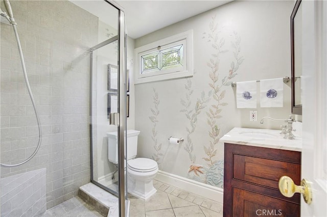 bathroom featuring toilet, vanity, tile patterned floors, and a shower with shower door