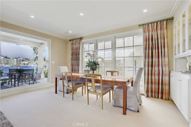 carpeted dining space with ornamental molding