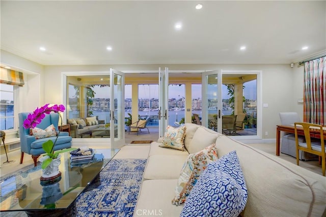 living room with light colored carpet, crown molding, french doors, and a healthy amount of sunlight