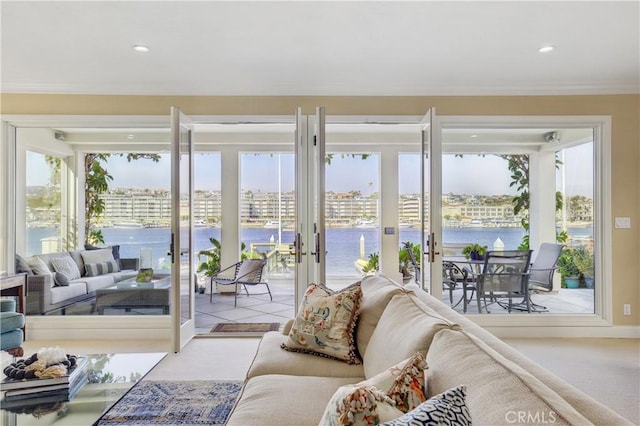 interior space featuring french doors, crown molding, a water view, and plenty of natural light