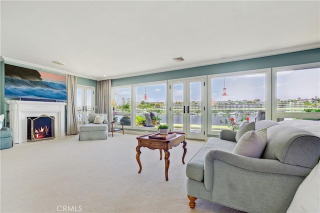 living room with a water view, light colored carpet, french doors, and ornamental molding