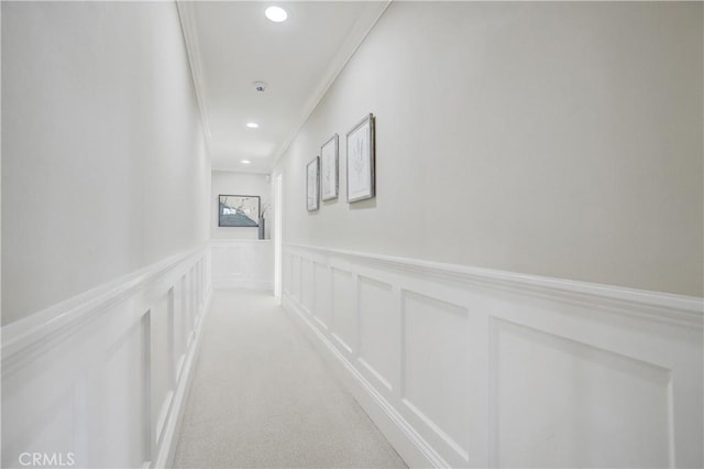 hallway featuring light carpet and crown molding