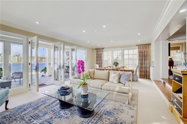 living room featuring light carpet, a wealth of natural light, and crown molding