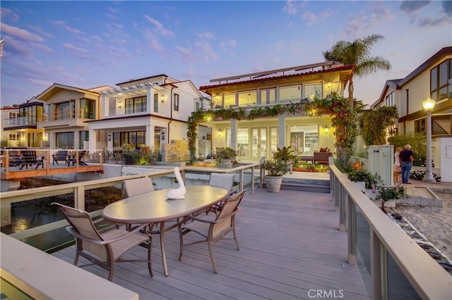 deck at dusk featuring a pergola