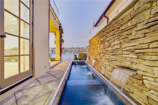 pool at dusk with pool water feature