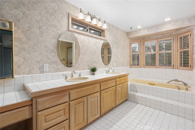 bathroom with tiled bath, vanity, and tile patterned floors