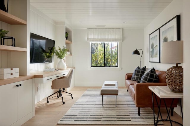 office with built in desk and light wood-type flooring