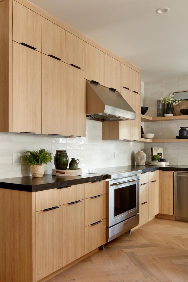 kitchen with exhaust hood, light parquet floors, light brown cabinetry, tasteful backsplash, and stainless steel appliances