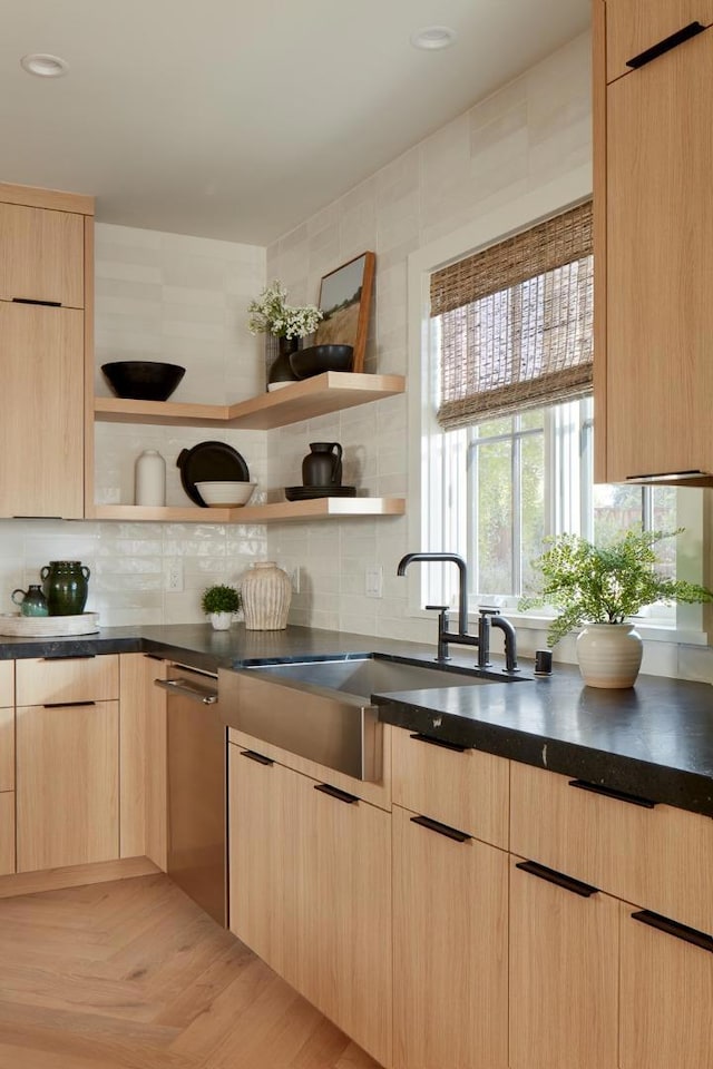 kitchen featuring backsplash, parquet floors, sink, and light brown cabinetry