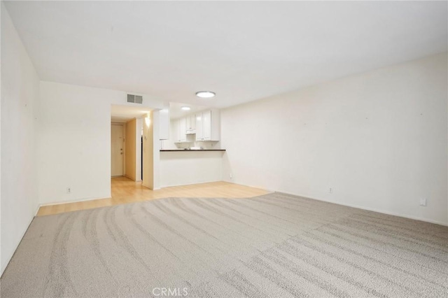 unfurnished living room featuring light carpet