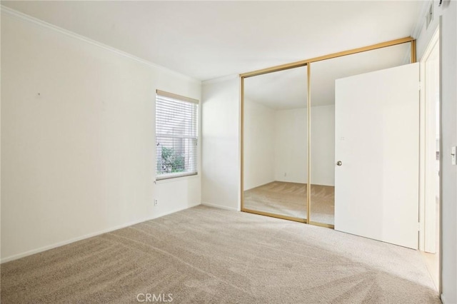 unfurnished bedroom featuring a closet, carpet, and ornamental molding