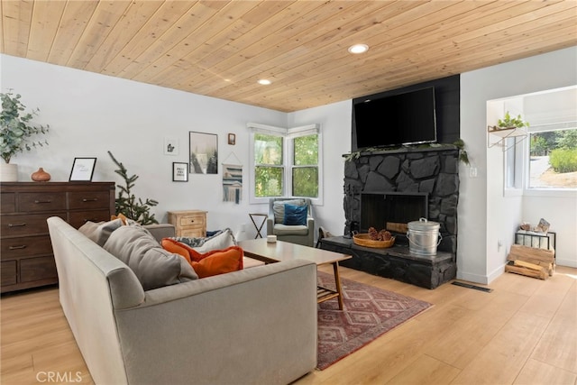 living room featuring light hardwood / wood-style floors, wooden ceiling, and a fireplace