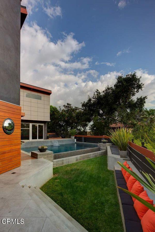 view of pool featuring a lawn and a patio