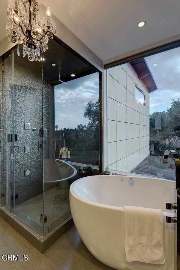 bathroom featuring tile walls and a chandelier