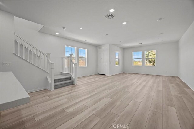 unfurnished living room with a wealth of natural light and light hardwood / wood-style floors