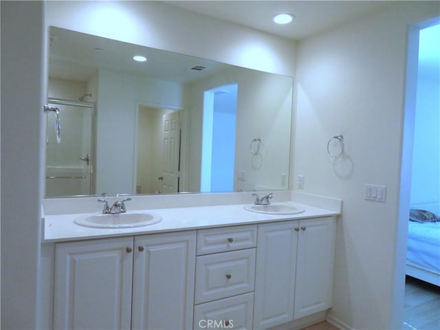 bathroom with wood-type flooring, vanity, and a shower with door