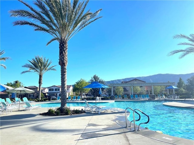 view of swimming pool featuring a patio area and a mountain view