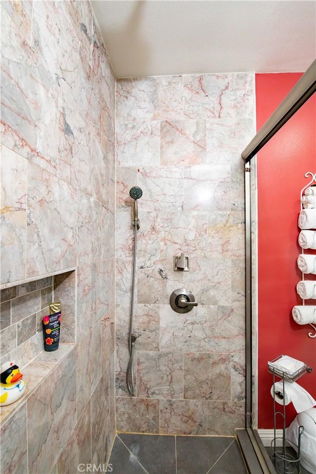 bathroom with tile patterned flooring and a tile shower