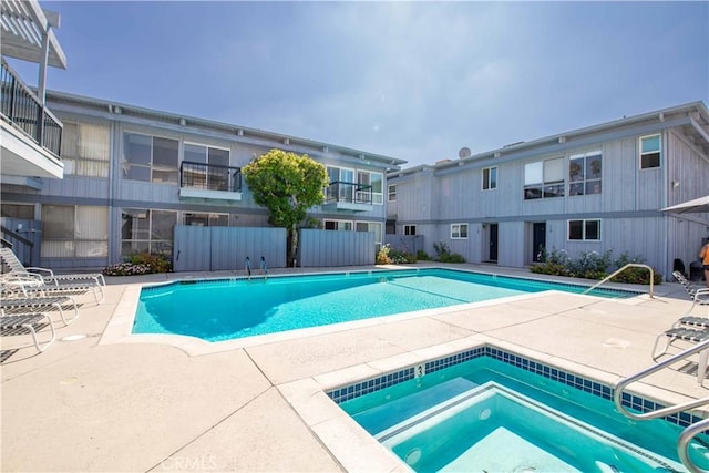 view of swimming pool featuring a community hot tub and a patio