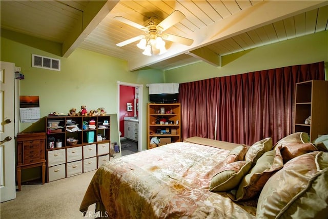 bedroom featuring beam ceiling, ensuite bath, ceiling fan, wooden ceiling, and light carpet