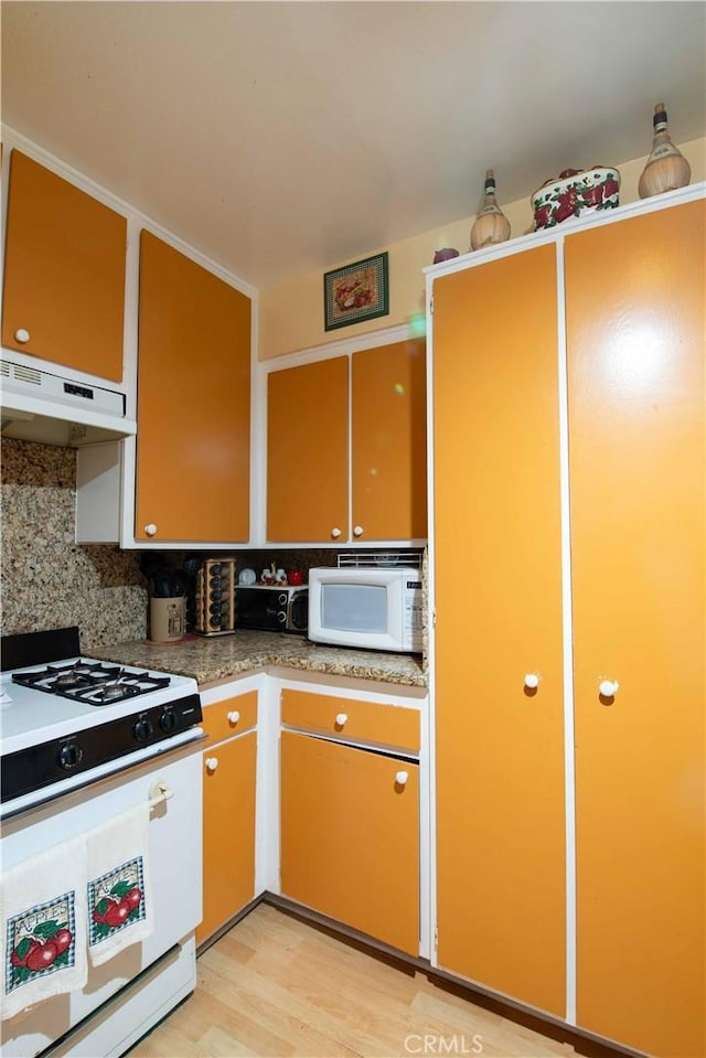 kitchen with light wood-type flooring, white appliances, ventilation hood, and tasteful backsplash