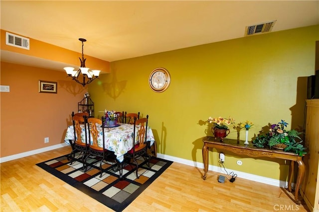 dining room with hardwood / wood-style floors and a chandelier