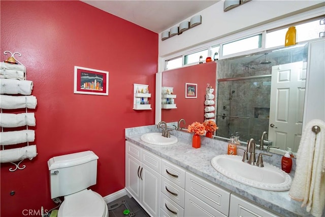 bathroom featuring vanity, toilet, and a shower with shower door