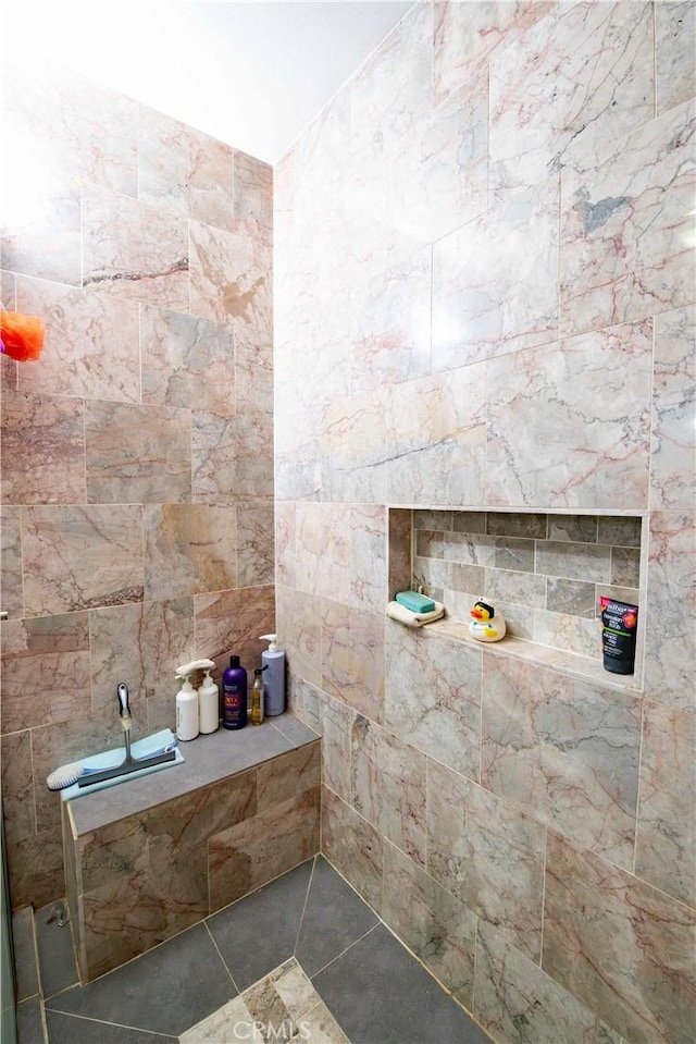 bathroom featuring a shower, tile patterned flooring, and tile walls