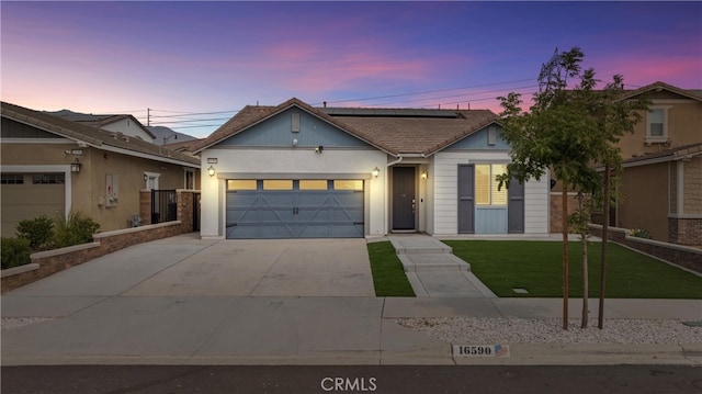 view of front of home featuring a garage and a lawn