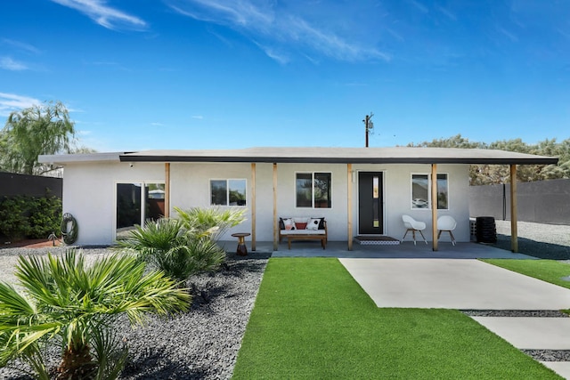 back of house featuring a lawn and a patio area