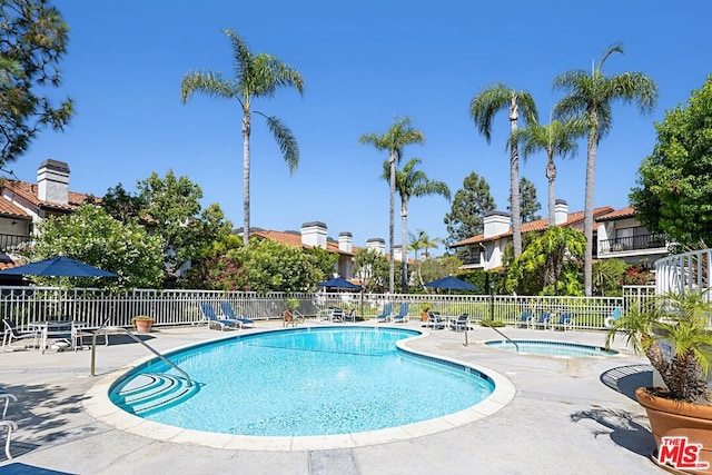 view of swimming pool featuring a patio area and a community hot tub