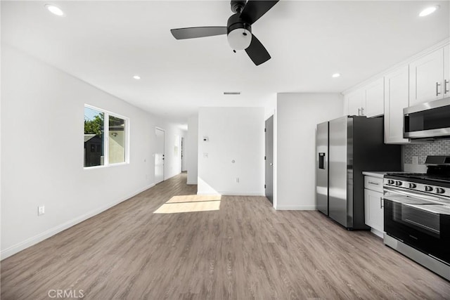 kitchen featuring white cabinets, ceiling fan, tasteful backsplash, light hardwood / wood-style floors, and stainless steel appliances