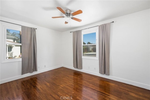 empty room with ceiling fan, plenty of natural light, and hardwood / wood-style flooring