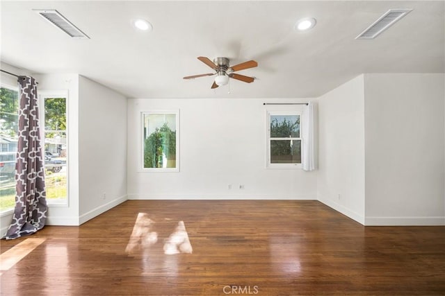 spare room with a wealth of natural light and hardwood / wood-style floors