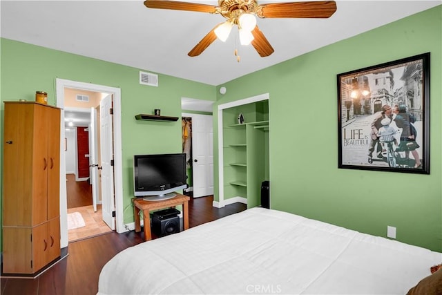 bedroom with ceiling fan, dark hardwood / wood-style flooring, and a closet