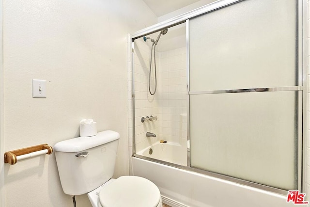 bathroom with combined bath / shower with glass door and toilet