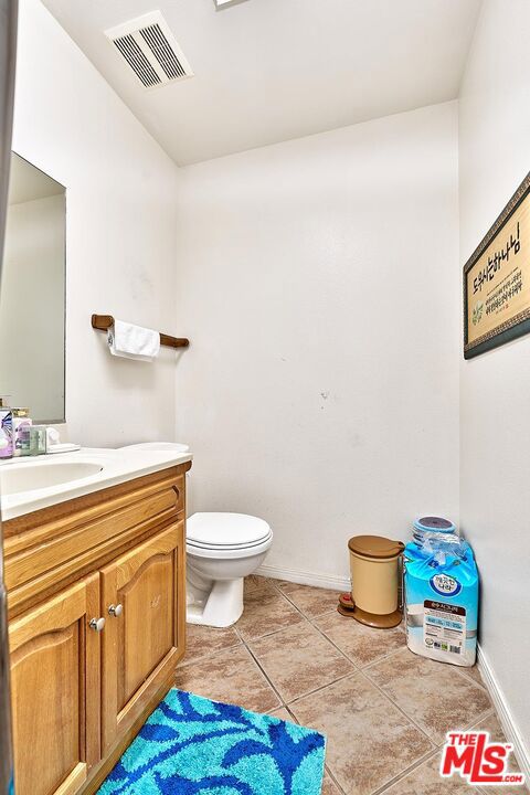 bathroom with vanity, toilet, and tile patterned floors