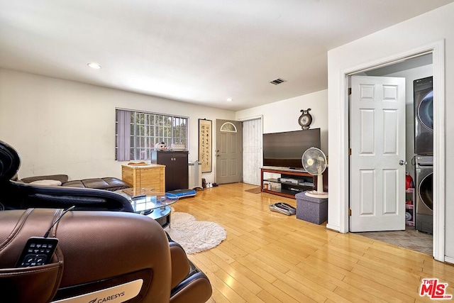 living room with hardwood / wood-style flooring and stacked washer and clothes dryer