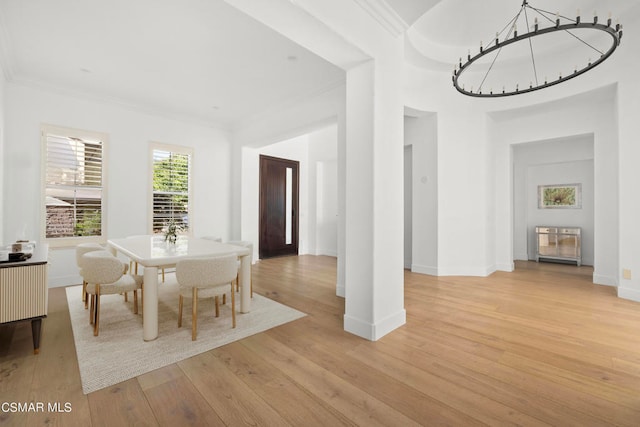 dining space with light wood-type flooring and crown molding