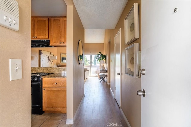 hall featuring light hardwood / wood-style floors and a textured ceiling