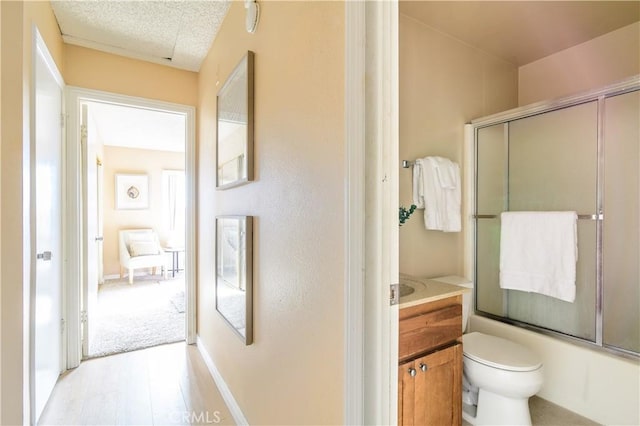 full bathroom with vanity, enclosed tub / shower combo, and toilet