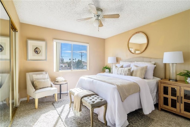 bedroom with ceiling fan, carpet floors, and a textured ceiling