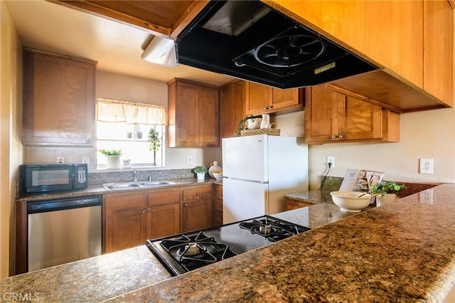 kitchen featuring black appliances, sink, extractor fan, and dark stone counters