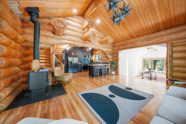 living room featuring lofted ceiling with beams, bar area, wood-type flooring, wooden ceiling, and log walls