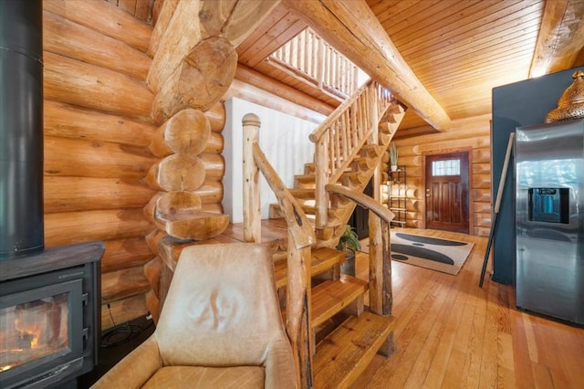 staircase featuring wood-type flooring, rustic walls, and wooden ceiling