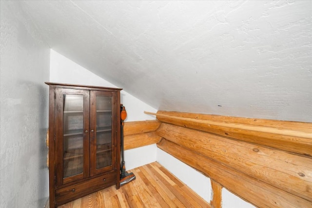 bonus room with vaulted ceiling and hardwood / wood-style flooring