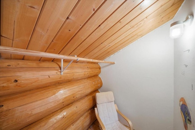 living area with wooden walls, vaulted ceiling, and wood ceiling